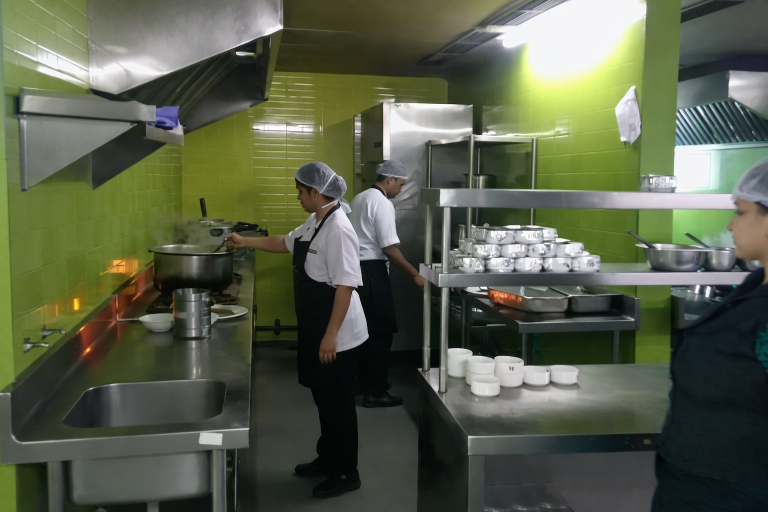 Clean modern restaurant kitchen with gleaming stainless steel countertops and organized cooking stations